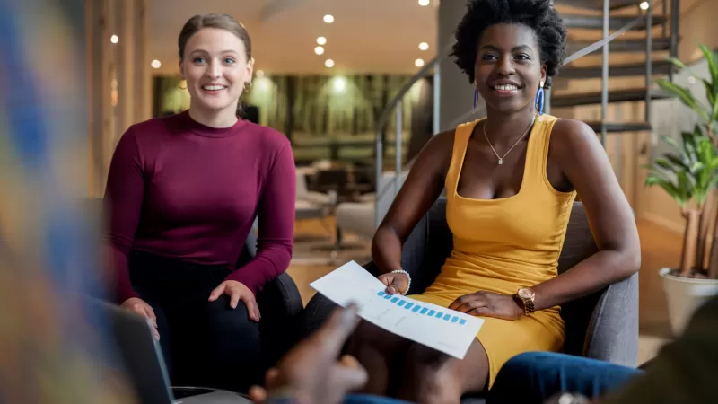 Two women collaborating on a project in a casual work environment